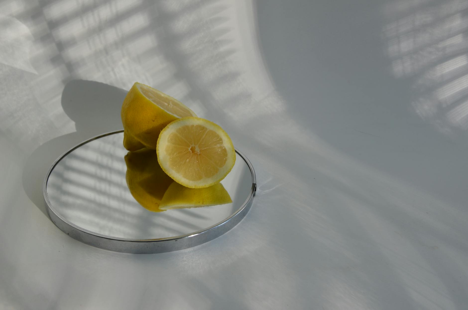 Sliced lemons on a mirror with soft shadows, representing efficiency and clarity in intimate moments