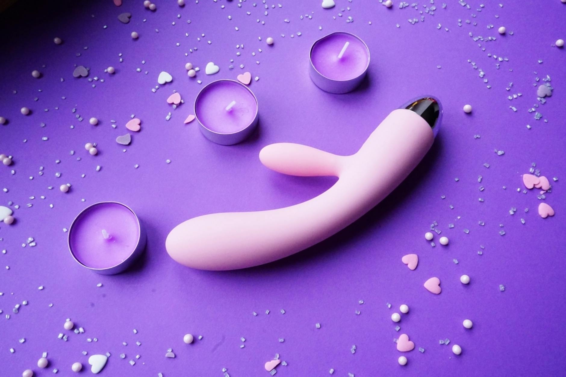 Lemon clitoral vibrator on a romantic surface with heart confetti and candles